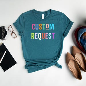 May include: Teal blue t-shirt with the text "CUSTOM REQUEST" in rainbow colors.