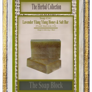 May include: Two bars of green and white soap with a label that reads "The Herbal Collection Soap #341 Lavender Ylang Ylang Honey & Salt Bar (Proudly Made in the USA) Image is showing 2 Bars The Soap Block"