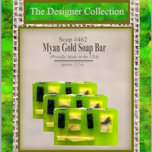 Puede incluir: Tres barras de jabón verde y negro con motas doradas. El jabón está etiquetado como "Myan Gold Soap Bar" y "Soap #462". La etiqueta también indica "Proudly Made in the USA" y "Approx. 5.2 oz".