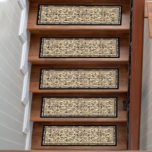 May include: Stair treads featuring a beige and black floral design. The rectangular treads are edged with a black border and are fitted on wooden stairs with a warm brown finish. These treads provide a decorative and safety element to the staircase.