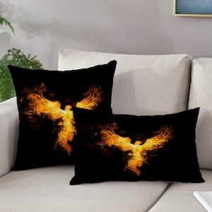 May include: Two decorative throw pillows with a black background and a fiery orange phoenix design.