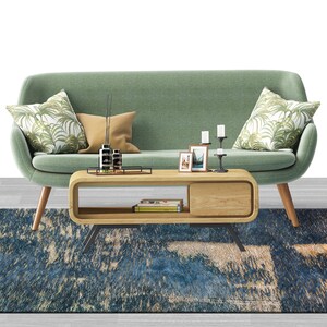 May include: A living room with a green sofa, two orange armchairs, a wooden coffee table with a black metal frame, and a blue and beige patterned rug. The sofa has two throw pillows with a tropical leaf pattern and a brown throw pillow.