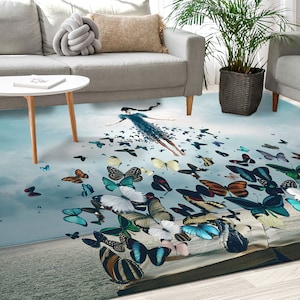 May include: A blue and white area rug with a whimsical design featuring a woman flying amongst a swarm of colorful butterflies. The rug has a faded, vintage look and is perfect for adding a touch of whimsy to any room.