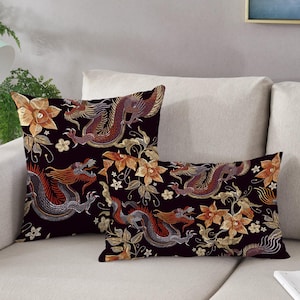 May include: Two decorative throw pillows with a black background and a repeating pattern of gold and red dragons and flowers.