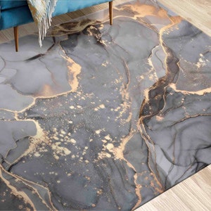Può includere: Tappeto da area astratto con un designo a marmo grigio e oro. Il tappeto ha un leggero luccichio e uno stile moderno e contemporaneo.