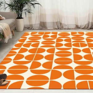 Peut inclure: Un tapis géométrique blanc et orange avec un motif répétitif de demi-cercles et de cercles pleins. Le tapis est fait d'un matériau doux et durable et est parfait pour ajouter une touche de style moderne à n'importe quelle pièce.
