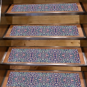 Op de afbeelding: Traptreden met een marineblauw bloemenpatroon. Het patroon bevat rode, roze en groene bloemelementen. De treden zijn geplaatst op houten trappen met metalen randen.