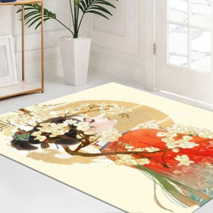 May include: A cream-coloured rug with a colourful illustration of a woman with long black hair wearing a red and green robe. The woman is surrounded by white flowers and a gold circle.