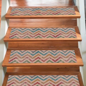 May include: A wooden staircase with four steps, each fitted with a patterned runner. The runners display a chevron design in blue, red, yellow, and green, providing a decorative element to the steps.