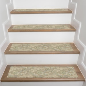 May include: Stair treads with a paisley pattern in shades of beige, green, and white are installed on wooden steps. The steps are painted white, and the risers are a light brown color. The paisley design adds a decorative touch to the staircase.