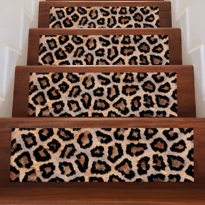 Puede incluir: Peldaños de escalera con un estampado de leopardo. Las huellas son rectangulares y presentan un diseño repetido de manchas negras y marrones sobre un fondo beige. Las huellas están instaladas en escaleras de madera.