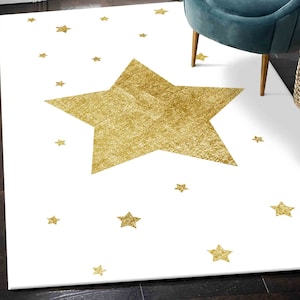 May include: A white area rug with a large gold glitter star in the centre. Smaller gold glitter stars are scattered around the large star.