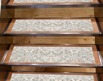 May include: Stair treads with a cream-colored, patterned design. The treads feature a geometric pattern in shades of gray, brown, and peach. The treads are rectangular and are set on wooden stairs with metal edging.