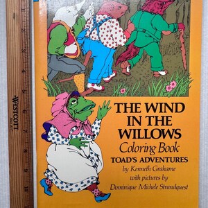 May include: A vintage "The Wind in the Willows" coloring book with a bright orange cover. The cover features illustrations of anthropomorphic animals and the title text. The book is 8 inches tall.