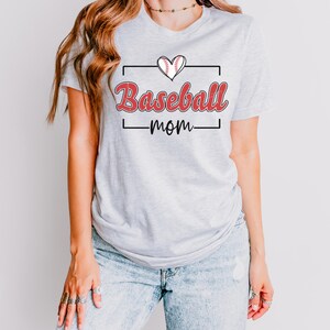 Puede incluir: Una camiseta gris con un gráfico de béisbol rojo y el texto "Baseball mom" en una fuente roja de estilo manuscrito.