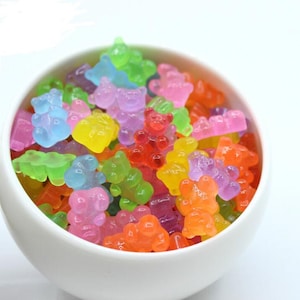 May include: A bowl filled with colorful gummy bear shaped candies. The gummy bears are in various shades of red, orange, yellow, green, blue, and purple.