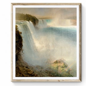 May include: A painting of Niagara Falls, depicting the cascading water and a rainbow in the mist. The painting is in a light brown frame.