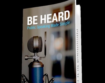 Könnte beinhalten: Ein Buch mit dem Titel "Be Heard: Public Speaking Made Simple" mit einem Mikrofon im Vordergrund. Das Mikrofon ist silber und schwarz mit einem blauen Ständer.