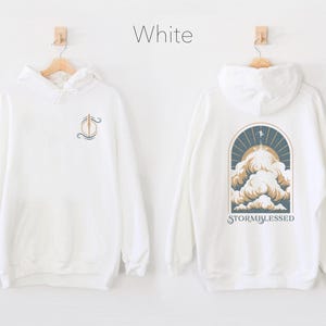 May include: White hooded sweatshirt with a graphic of a cloud with the text "STORMBLESSED" on the back and a small graphic on the front.