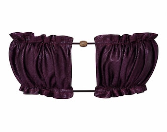 May include: A dark purple, metallic-finish bandeau top featuring a gathered, ruffled texture along the top and bottom edges. The two sides are connected by thin dark cords, with a single small, light-colored wooden bead centered between them.