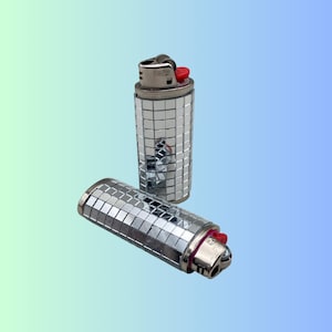 May include: Two silver lighters with a mirrored finish. The lighters have a red button and a silver top.