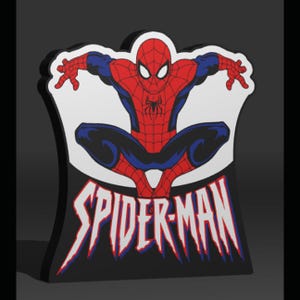 Może przedstawiać: Figurka Spider-Mana w pozycji kucznej, w czerwono-niebieskim kostiumie. Figurka stoi na czarnej podstawie z napisem "SPIDER-MAN" w kolorze białym i czerwonym. Tło jest ciemnoszare.