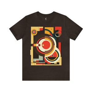 May include: A brown t-shirt with a geometric design featuring circles, squares, and rectangles in shades of red, yellow, orange, brown, black, and white.