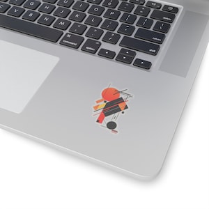 May include: Abstract geometric design sticker with a red, orange, and black color scheme. The sticker features a circle, squares, and lines.