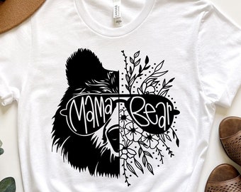 May include: White t-shirt with a black and white illustration of a bear wearing sunglasses and the text "Mama Bear".