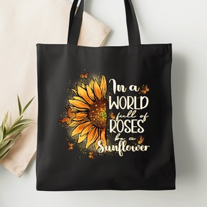 May include: Black tote bag with a sunflower graphic and the text "In a world full of roses be a sunflower".