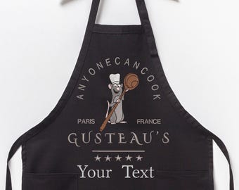 May include: Black apron with a white graphic of a rat chef holding a wooden spoon. The graphic is surrounded by a circle with the text "Anyone Can Cook" and the words "Paris" and "France". The text "Gusteau's" is below the graphic with four stars and the text "Your Text" below the stars.