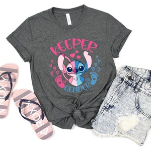 May include: Gray t-shirt with a blue and pink Stitch character and the text "Keeper of the Gender".