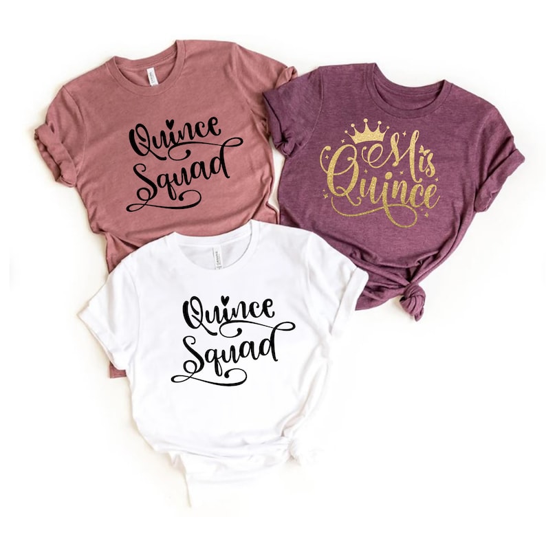 May include: Three t-shirts with different designs for a Quincea&ntilde;era celebration. One shirt is white with black text that says "Quince Squad". Another shirt is pink with black text that says "Quince Squad". The third shirt is purple with gold glitter text that says "Mrs. Quince" and a gold crown.