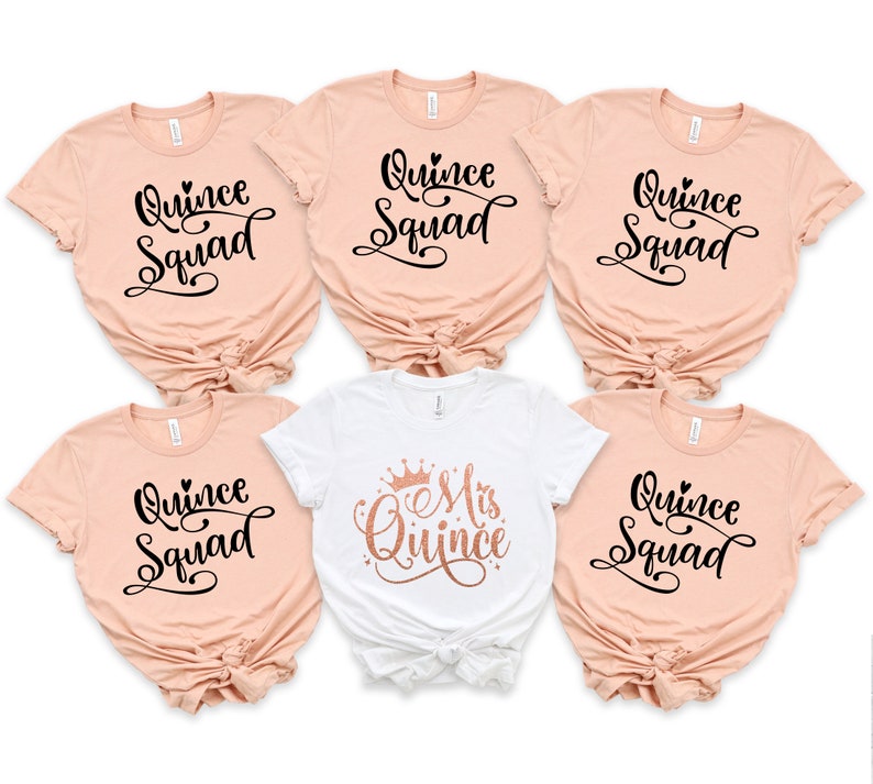 May include: Five t-shirts with the text "Quince Squad" in black script on a peach background. One white t-shirt with the text "Mis Quince" in rose gold script with a crown above the text.