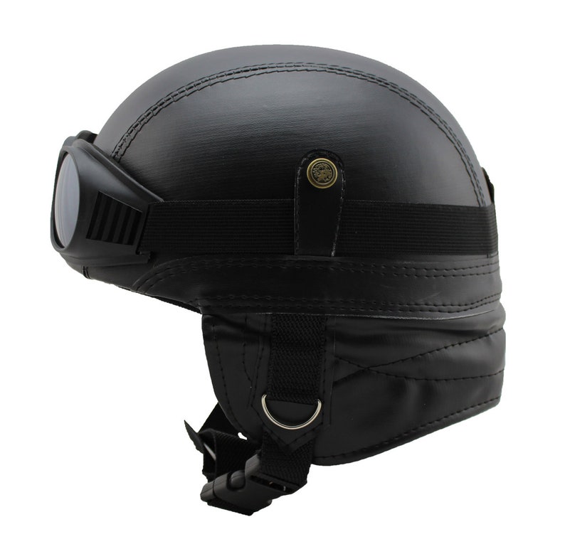 K&ouml;nnte beinhalten: Schwarzer Motorradhelm mit integrierter Brille. Der Helm hat ein gen&auml;htes Design und einen Kinnriemen mit Schnalle. Die Brille hat dunkle Gl&auml;ser. Der Helm ist f&uuml;r den Motorradgebrauch konzipiert.