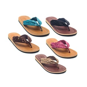 Op de afbeelding: Vier paar bruine leren sandalen met geknoopte banden versierd met pailletten. De sandalen zijn verkrijgbaar in turquoise, zwart, roze en beige.