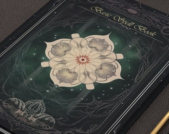 Può includere: Un diario con copertina rigida nera con un design floreale verde e bianco sulla copertina. Il titolo "Rose Spell Book" è scritto in lettere dorate sulla copertina.