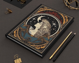 May include: A black notebook with a gold and blue illustration of a woman with long hair looking up at a crescent moon and stars. The notebook has a decorative border.