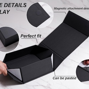 K&ouml;nnte beinhalten: Eine schwarze Faltbox mit magnetischem Verschluss. Die Box ist ge&ouml;ffnet und gibt den Blick ins Innere frei. Der Text "SOME DETAILS DISPLAY" ist oben links zu sehen, und "Perfect fit" steht auf der Seite der Box.