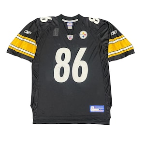 Pode incluir: Camisola de futebol preta com o número 86 em branco na frente. A camisola tem listras amarelas e brancas nas mangas e o logotipo dos Steelers de Pittsburgh no peito. A camisola é feita de um material de malha.