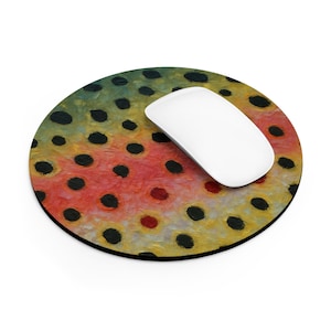 May include: Round mousepad with a colorful design resembling a brown trout. The mousepad features a pattern of red, yellow, and green hues with black spots. A white computer mouse rests on top of the mousepad.
