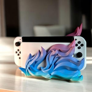 May include: A white Nintendo Switch console with blue and pink abstract flame design, standing upright on a wooden surface.