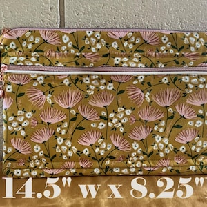 May include: A rectangular floral print pouch with a mustard yellow background, pink and white flowers, and a zipper closure. The pouch is 14.5 inches wide and 8.25 inches high.