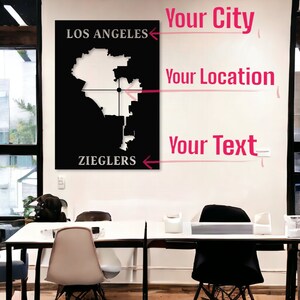 May include: A black and white map of Los Angeles, California, with the text "Los Angeles" and "Zieglers" printed on the top and bottom of the map. The map is mounted on a white wall with the words "Your City", "Your Location", and "Your Text" written in pink above the map.