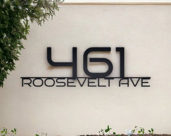 May include: A black and white sign with the number 461 and the text "ROOSEVELT AVE" on a beige wall.