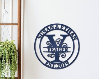 Peut inclure: Une plaque ronde en bois bleu marine avec le texte "Susan & Ethan Yeager Est. 2019" et une grande lettre "Y" bleue marine avec des volutes décoratives.