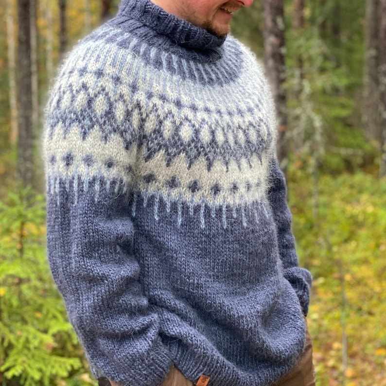 Puede incluir: Un su&eacute;ter azul y blanco con estampado y cuello alto. El su&eacute;ter est&aacute; hecho de un material suave y peludo.