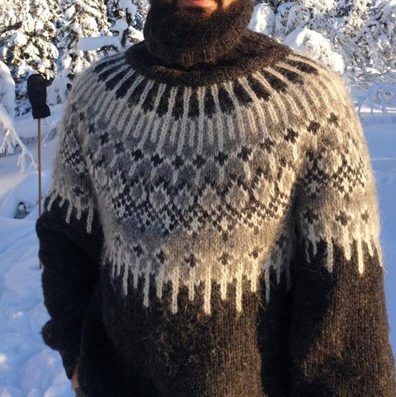 Puede incluir: Un su&eacute;ter de cuello alto con estampado en blanco y negro. El su&eacute;ter est&aacute; hecho de un material suave y peludo.