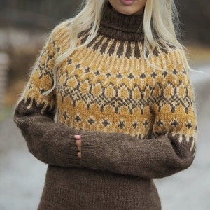 Puede incluir: Un su&eacute;ter de punto marr&oacute;n y amarillo con un patr&oacute;n geom&eacute;trico. El su&eacute;ter tiene cuello alto y mangas largas.