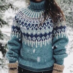 Puede incluir: Un su&eacute;ter de cuello alto azul, blanco y gris con un dise&ntilde;o de punto de trenza. El su&eacute;ter est&aacute; hecho de una tela suave y tejida.
